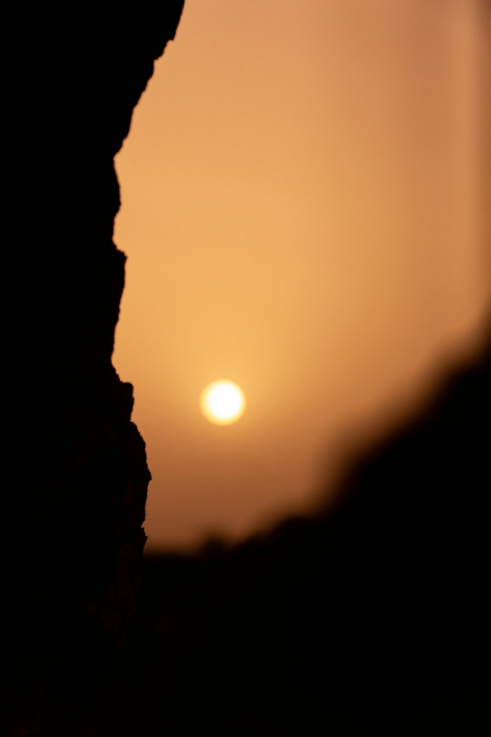 the sun is setting behind a rocky outcropping