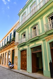 a couple of people sitting on a bench in front of a building