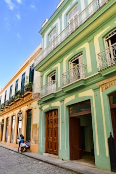 a couple of people sitting on a bench in front of a building