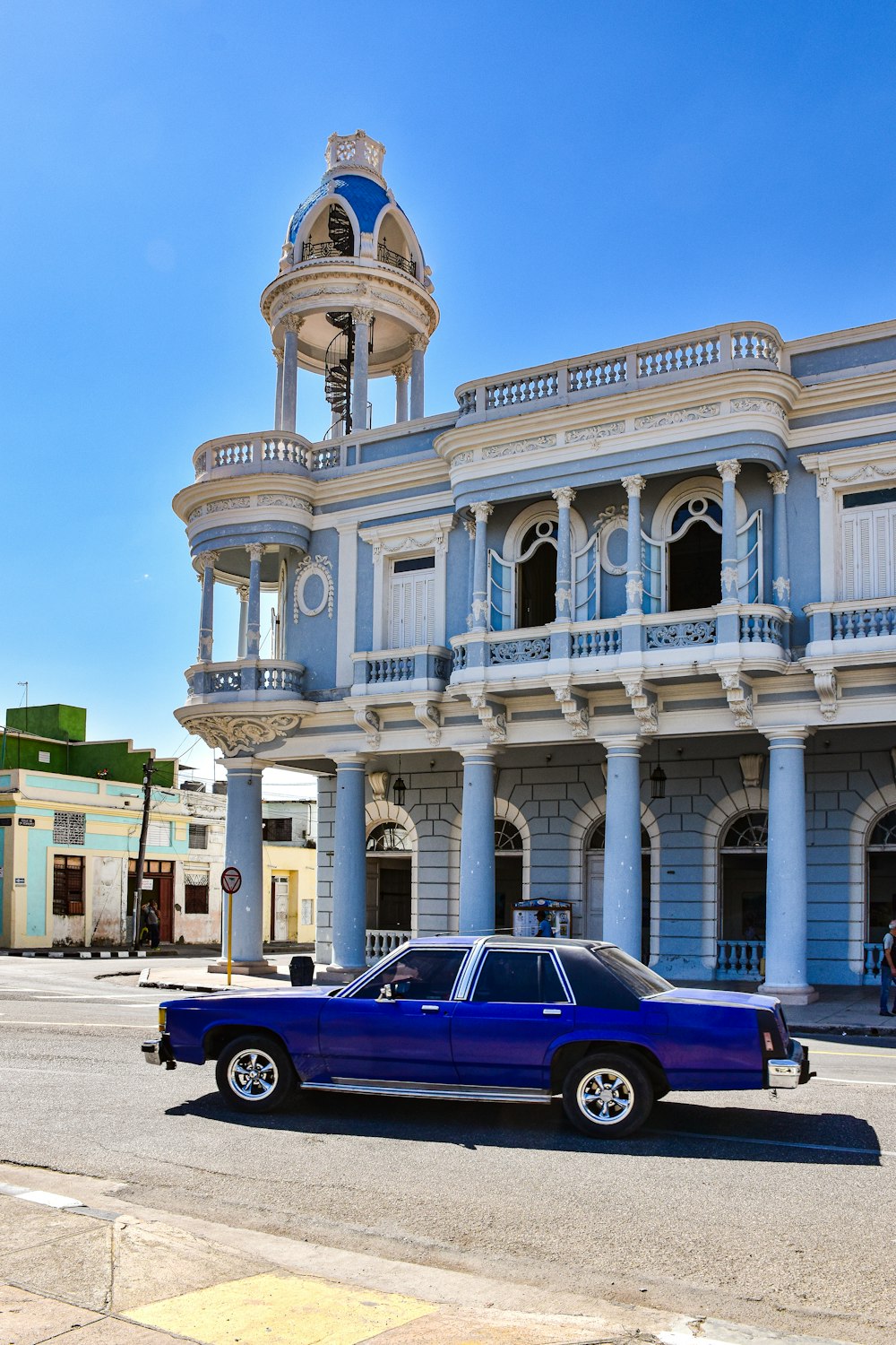 a blue car parked in front of a building