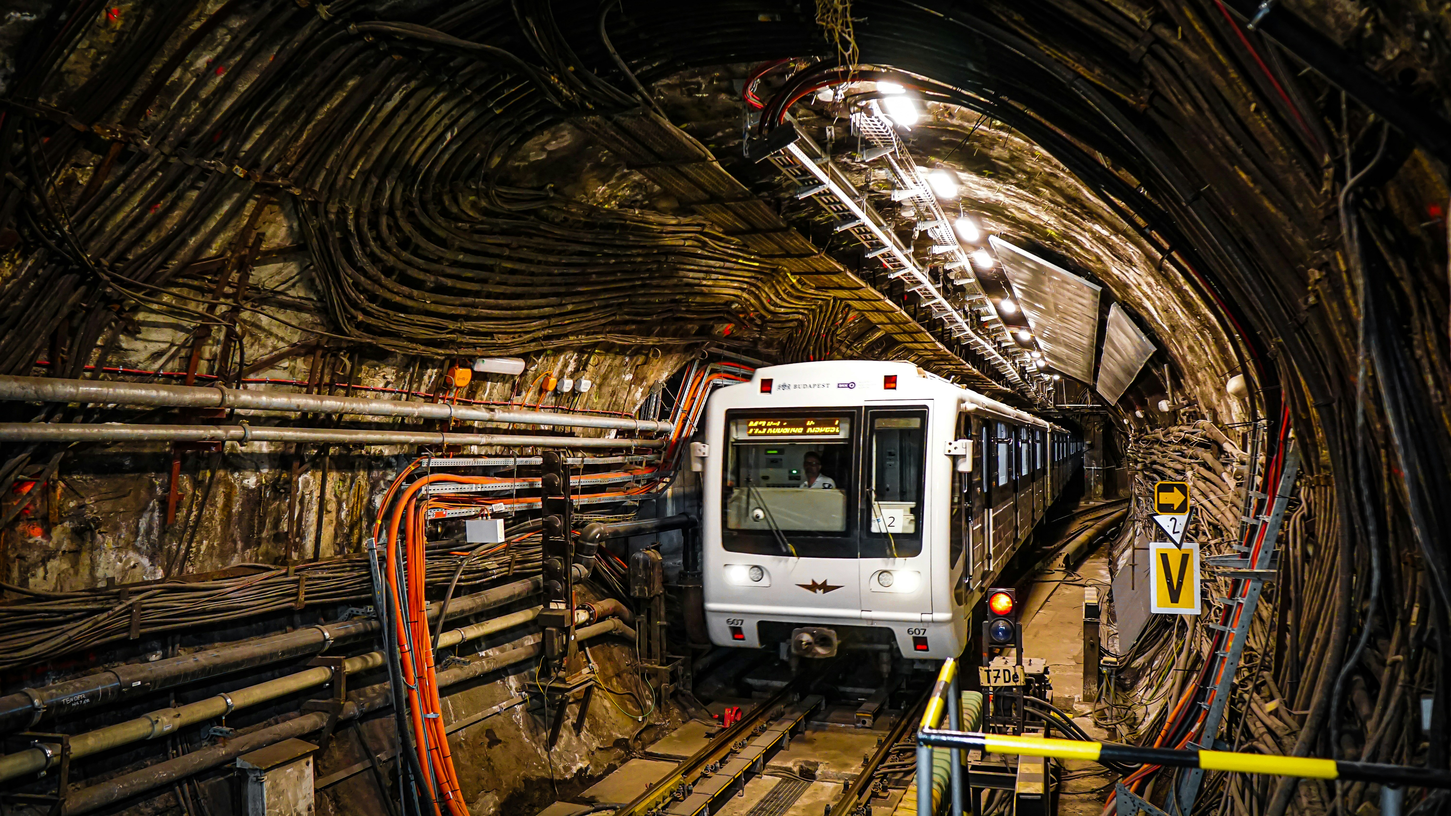 a subway train traveling through a tunnel filled with lots of wires