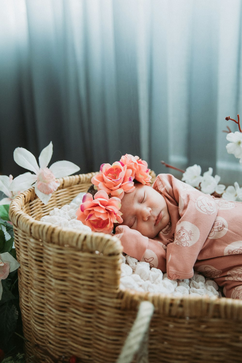 a baby is sleeping in a basket with flowers