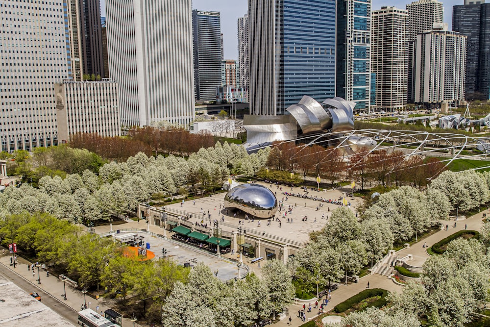an aerial view of a city park with trees and buildings in the background