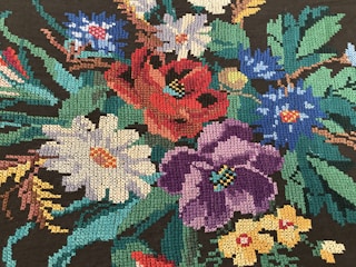 Close-up of colorful flat embroidery stitches on fabric with vibrant threads.