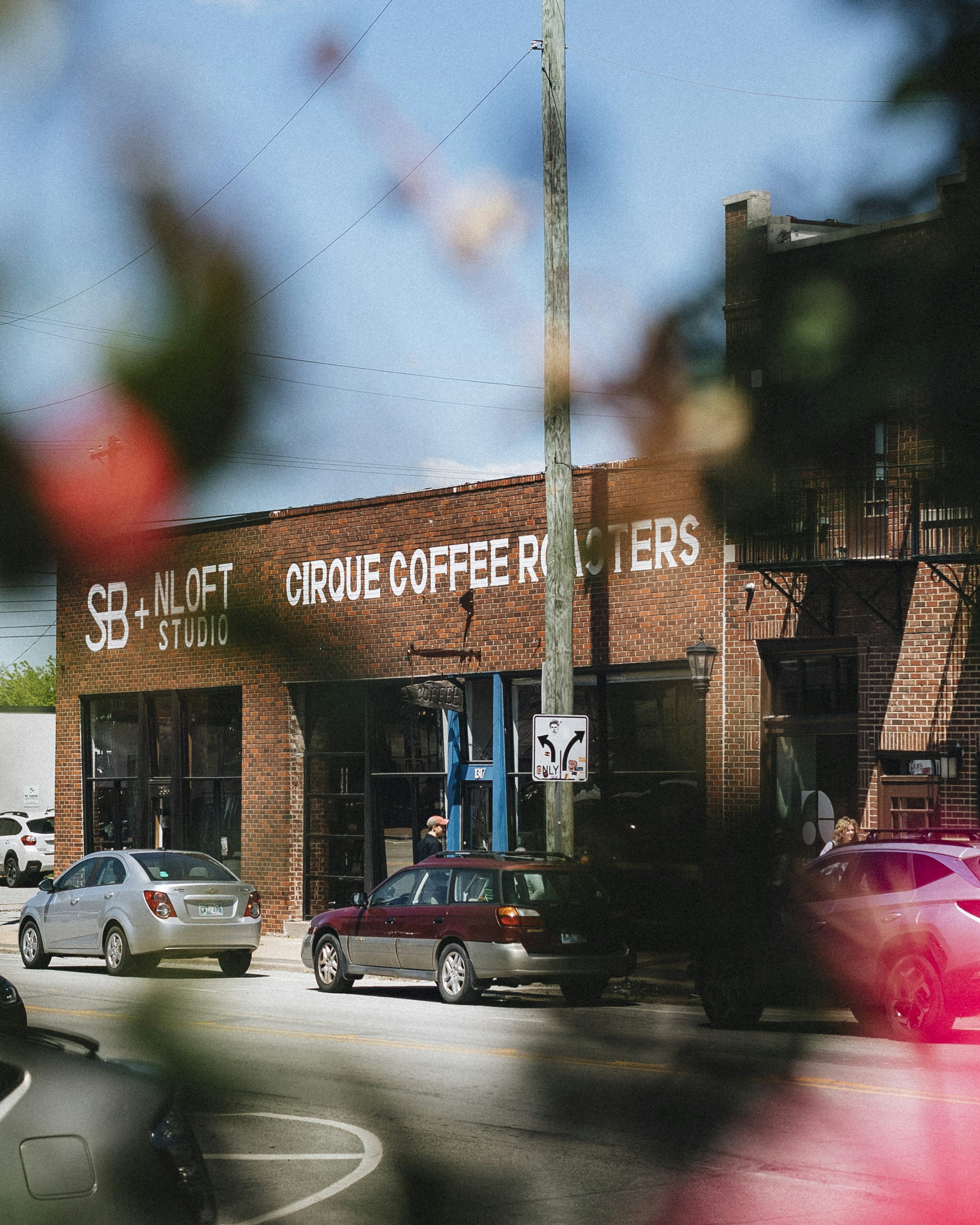 a group of cars parked in front of a coffee shop