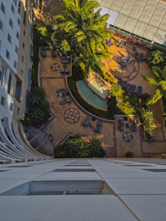 A wide shot of a landscaped courtyard with palm trees, walkways, and integrated lighting in a Jordan hotel