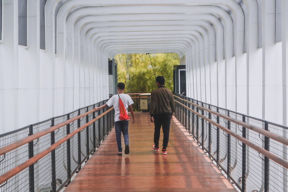 a couple of people walking across a bridge