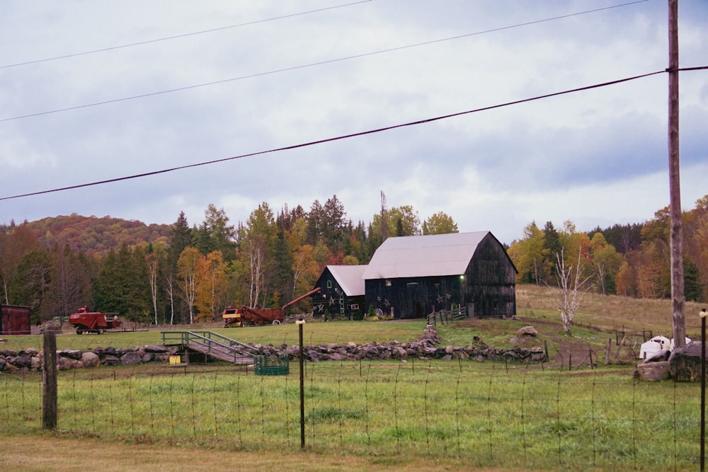 a farm with a barn and horses in the pasture