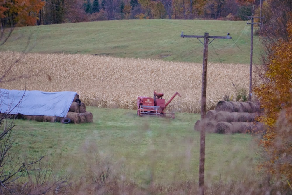 a farm field with hay bails and a tractor