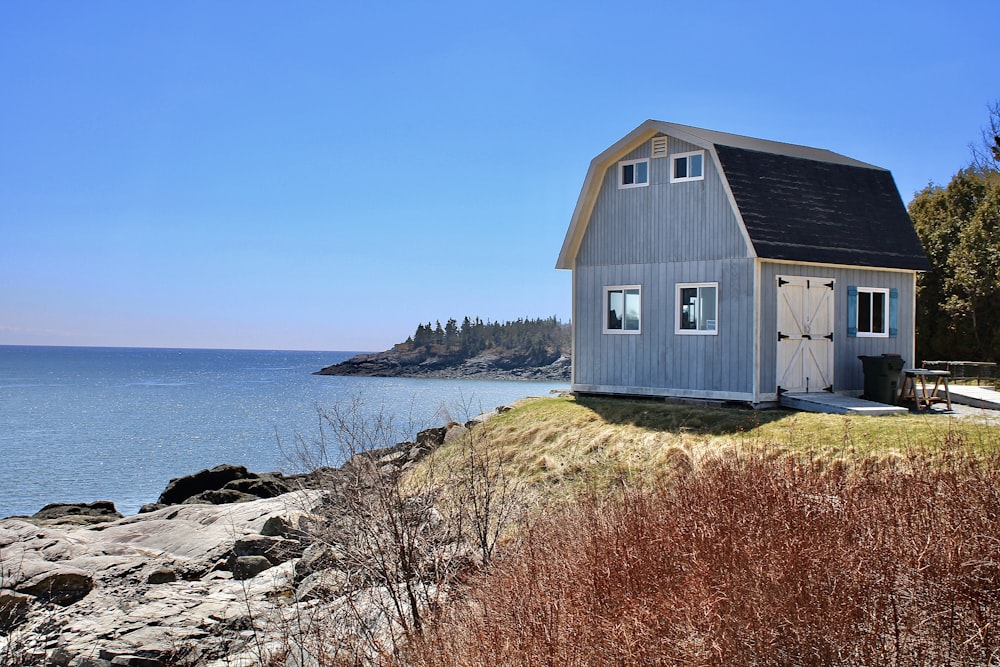 a house sitting on top of a cliff next to the ocean