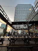 Cozy rooftop dining area at sunset with guests enjoying their meals under string lights.