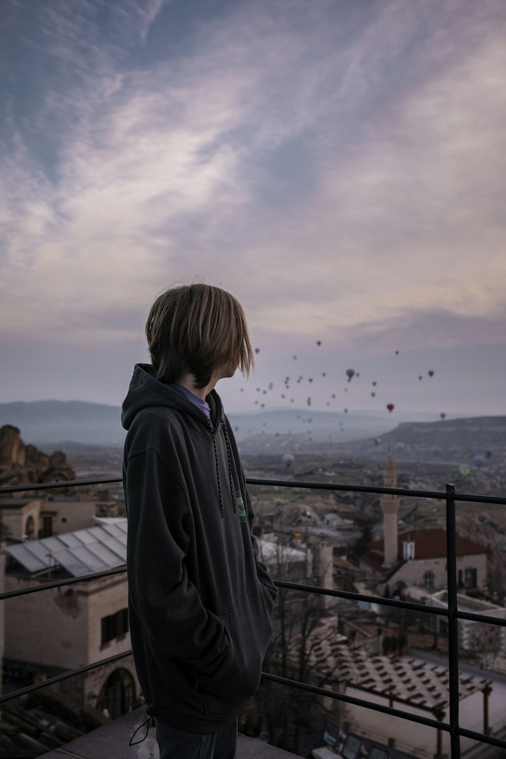 a man standing on top of a balcony next to a building