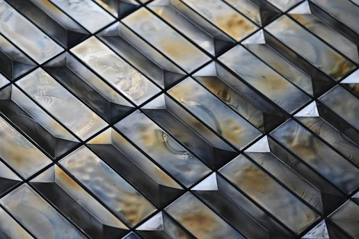 Close-up of glossy porcelain tiles arranged in a modern pattern showcasing texture and color.