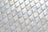 A pattern of iridescent, diamond-shaped tiles creating a textured surface with reflective qualities. The tiles are aligned in a grid with subtle color variations and swirling patterns visible on their surfaces.