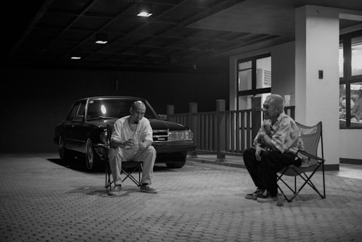 a man sitting in a chair next to another man