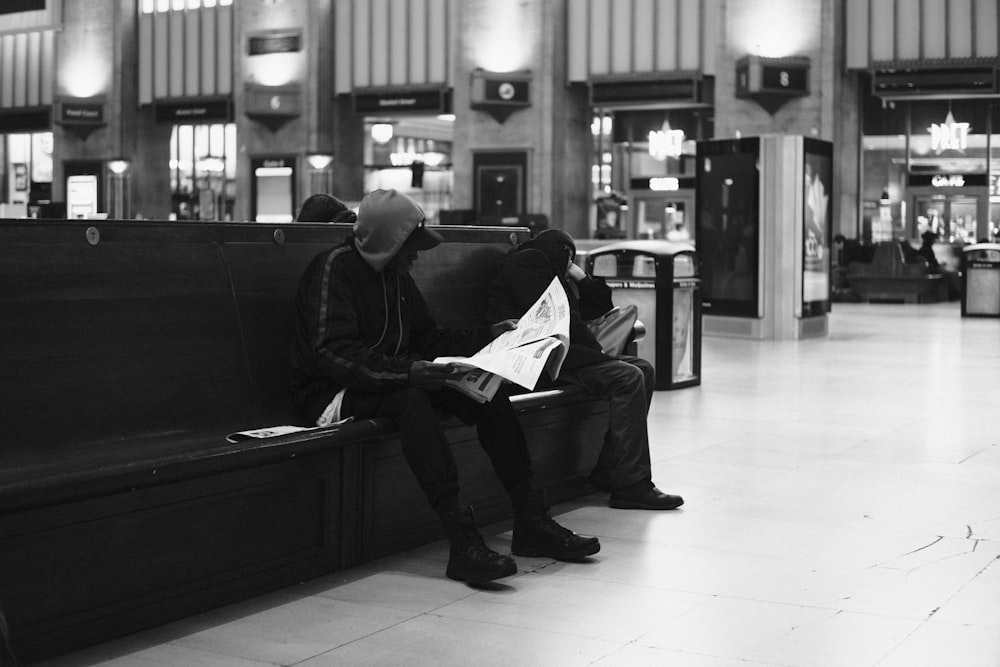 a couple of people sitting on a bench in a building