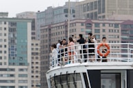 A group of friends taking photos on a boat deck.