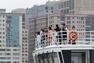 A group of friends taking photos on a boat deck.