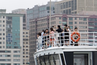 A group of friends taking photos on a boat deck.