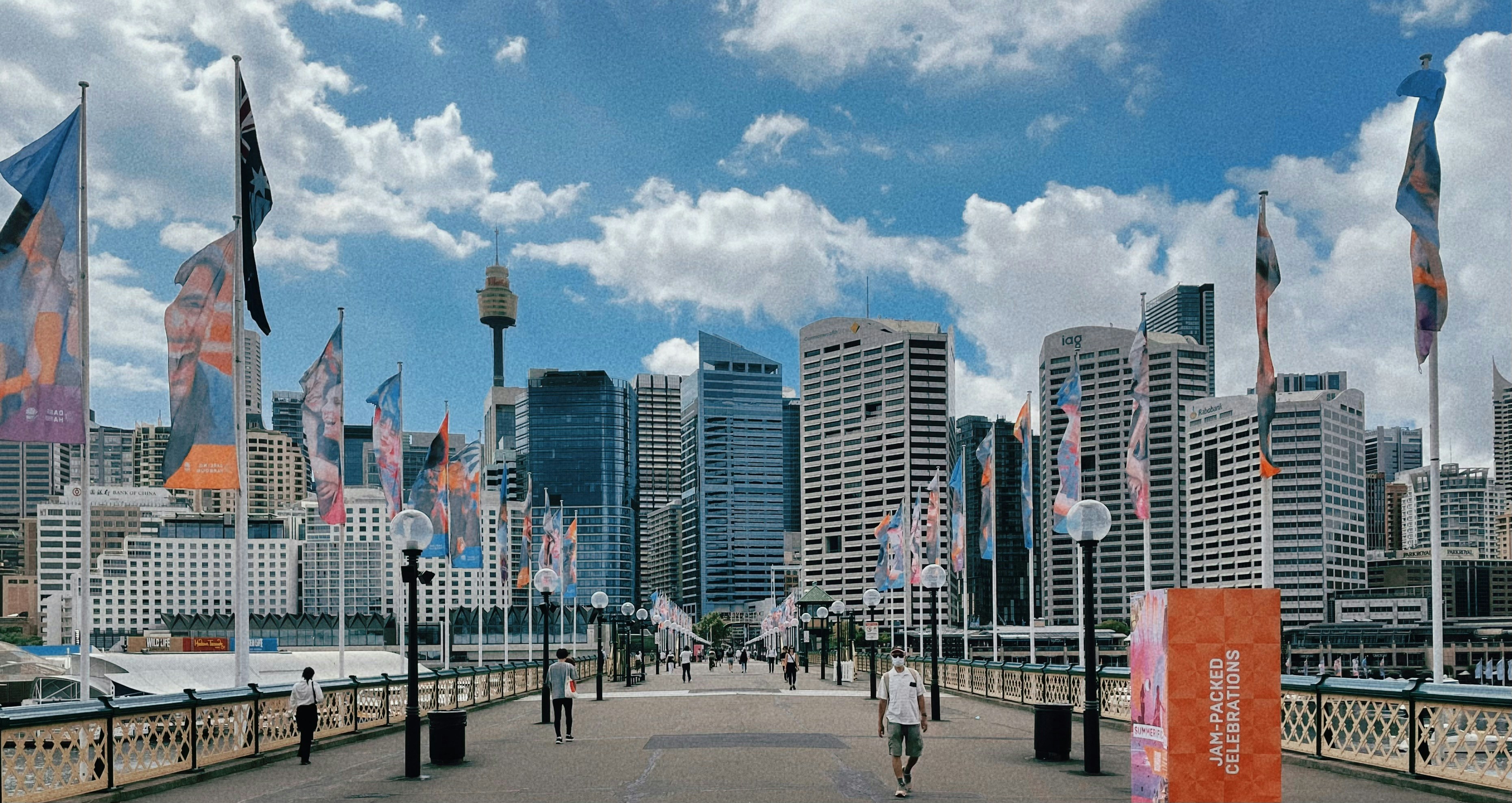 a person walking across a bridge with a city in the background