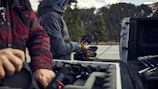 Film crew setting up camera equipment on a mountain location.