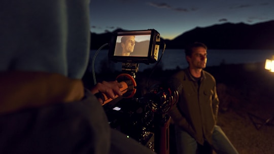 a man standing next to a man holding a camera