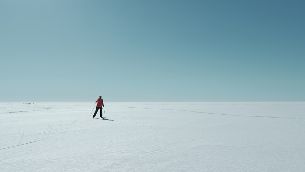 a person standing in the middle of a snow covered field