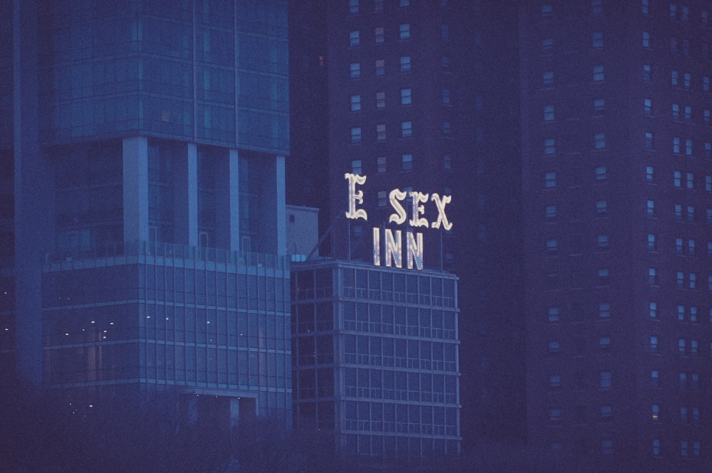 a tall building with a neon sign on top of it