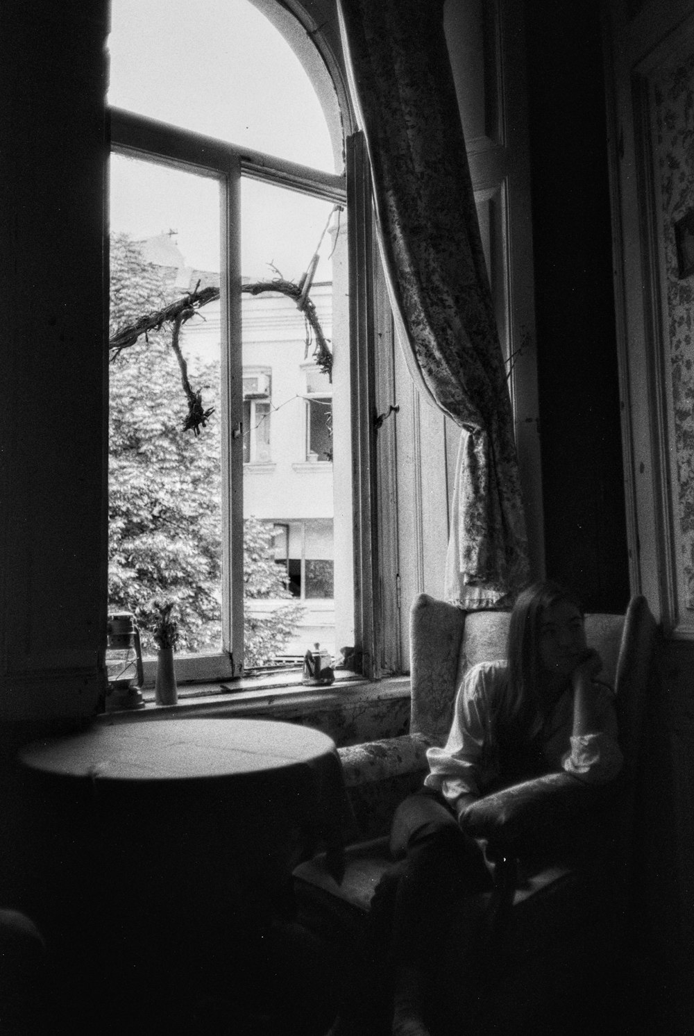 a woman sitting in a chair in front of a window