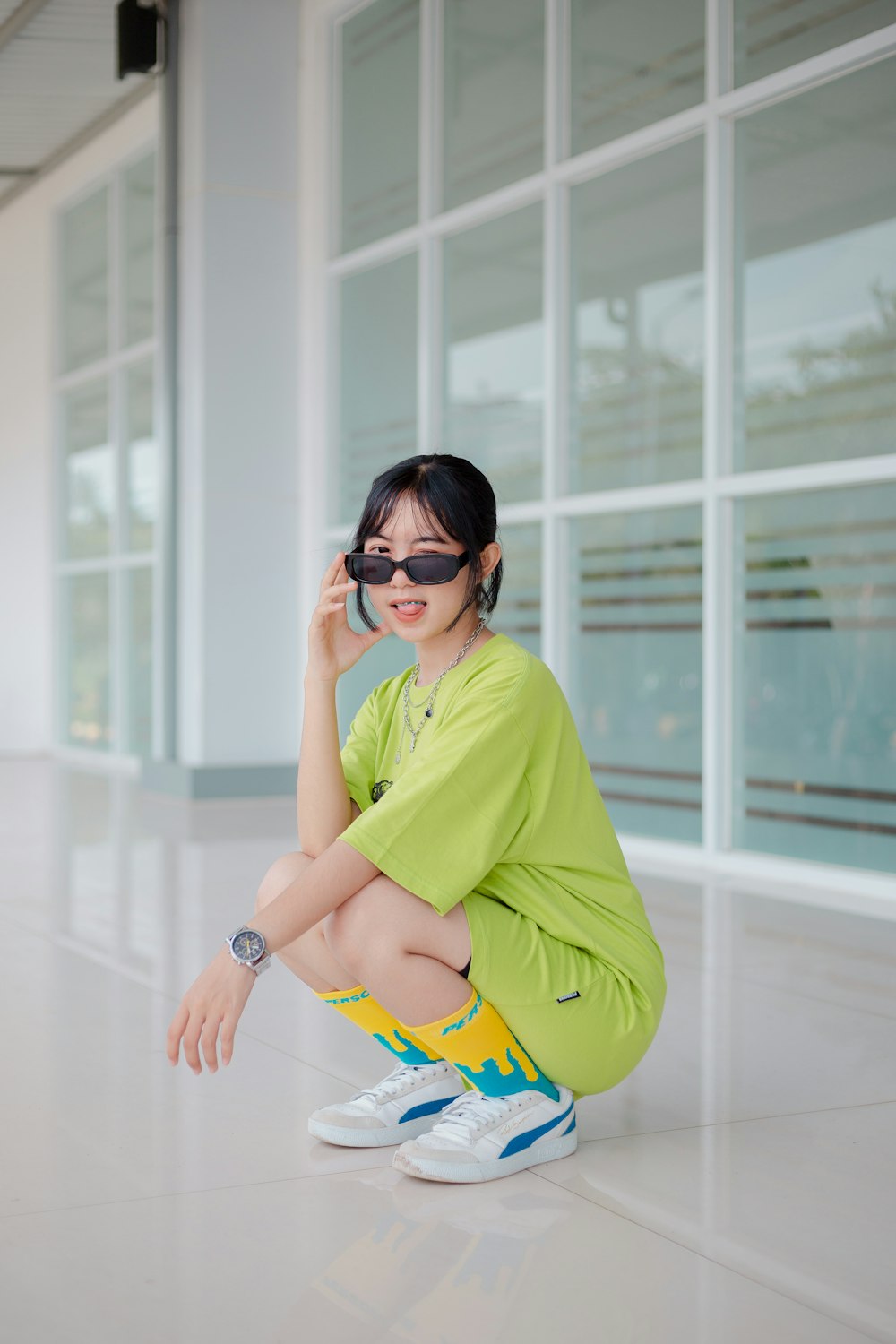 a woman sitting on the ground wearing sunglasses