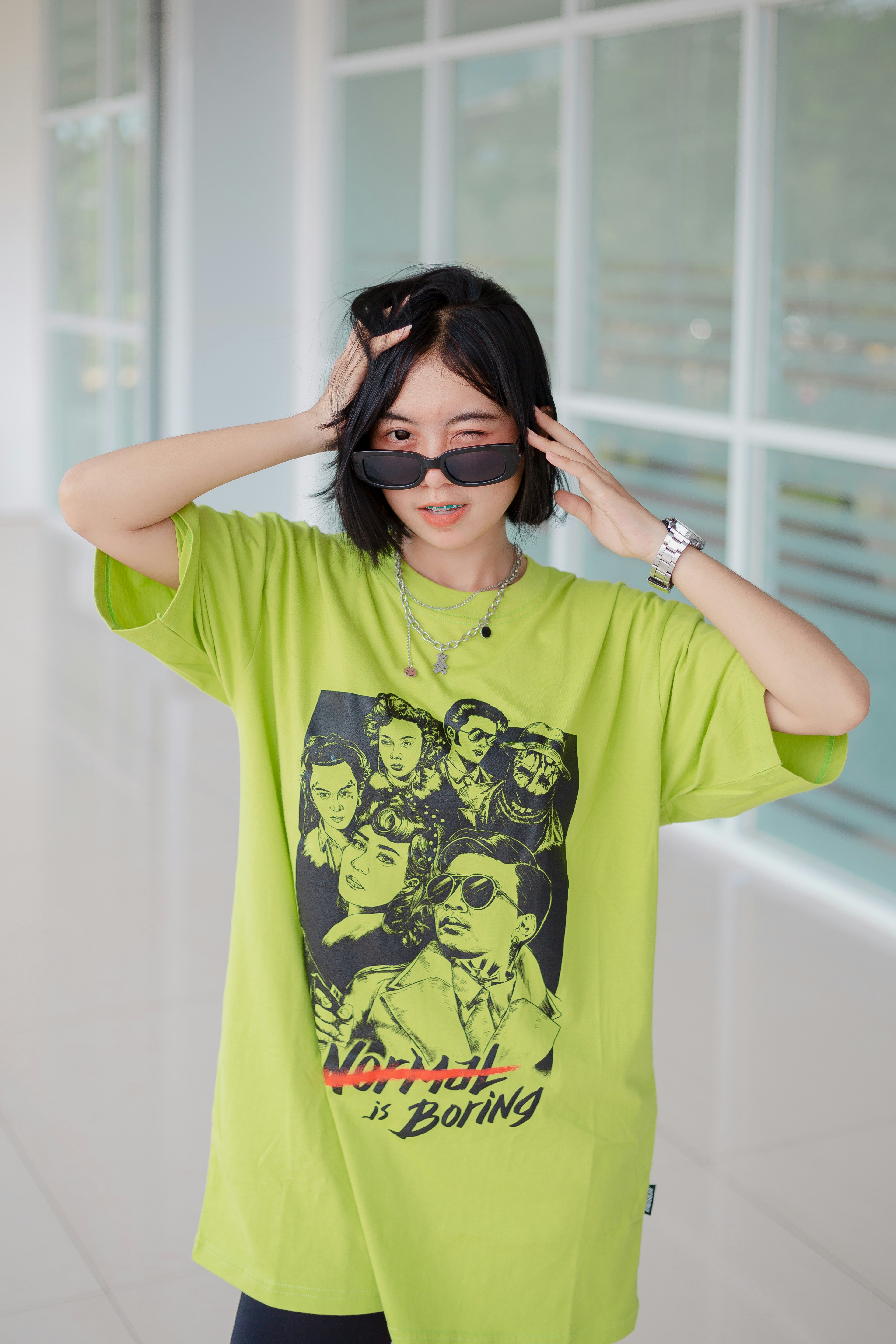 A woman wearing a green shirt with a black mask on her face photo ...