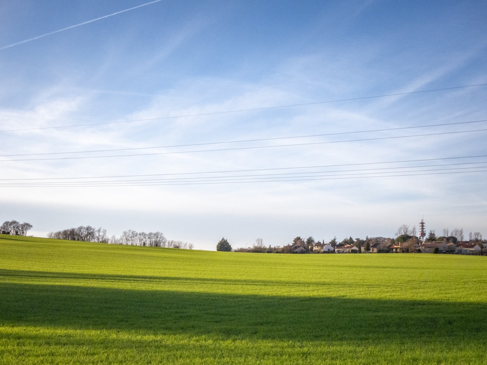 a green field with power lines in the distance