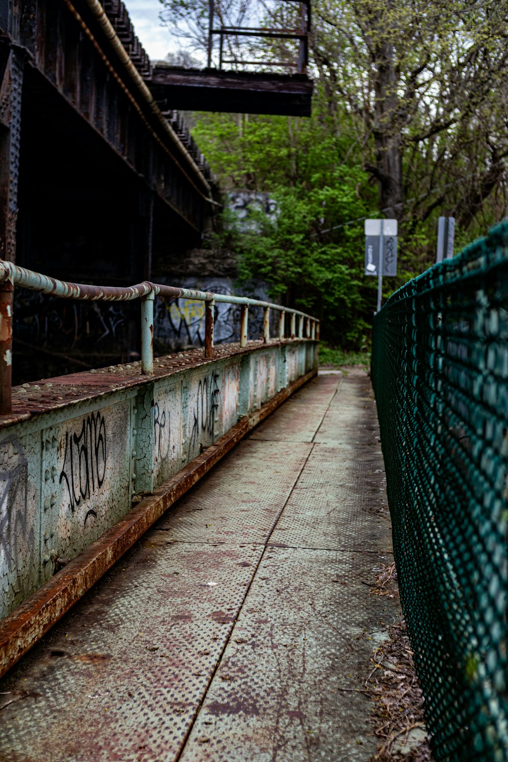 a rusty bridge with graffiti on the side of it