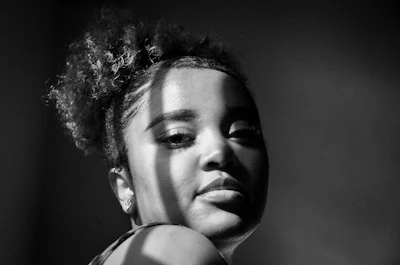 A delicate black and white portrait capturing natural light and subtle shadows.