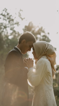 A serene image of a couple meditating together at sunset, surrounded by soft glowing light.