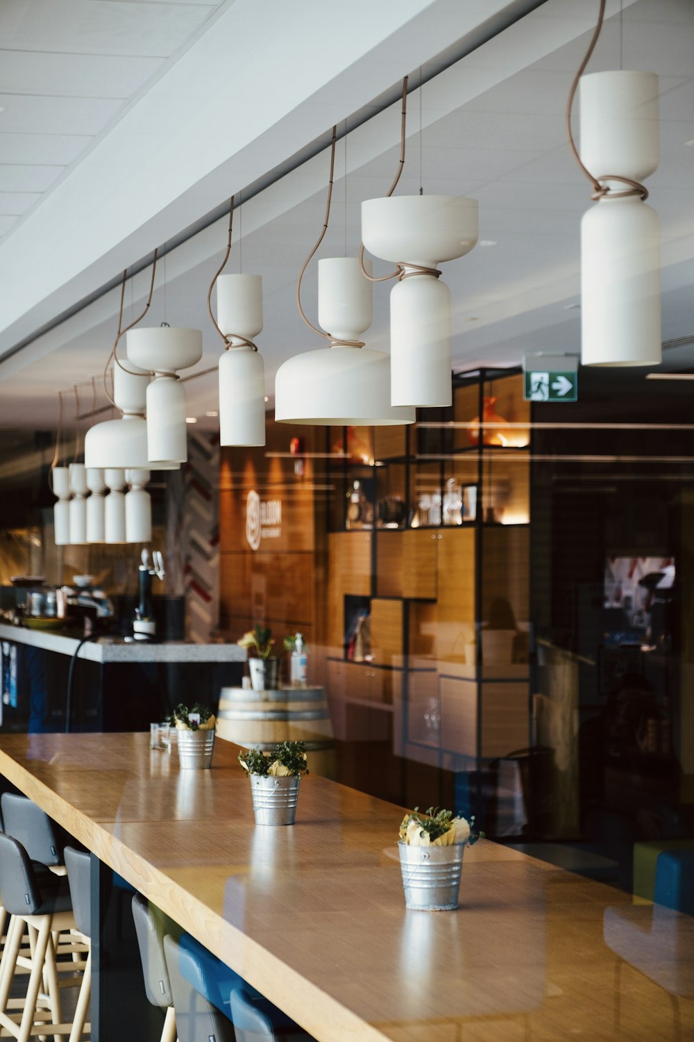 a restaurant with wooden tables and chairs and hanging lights