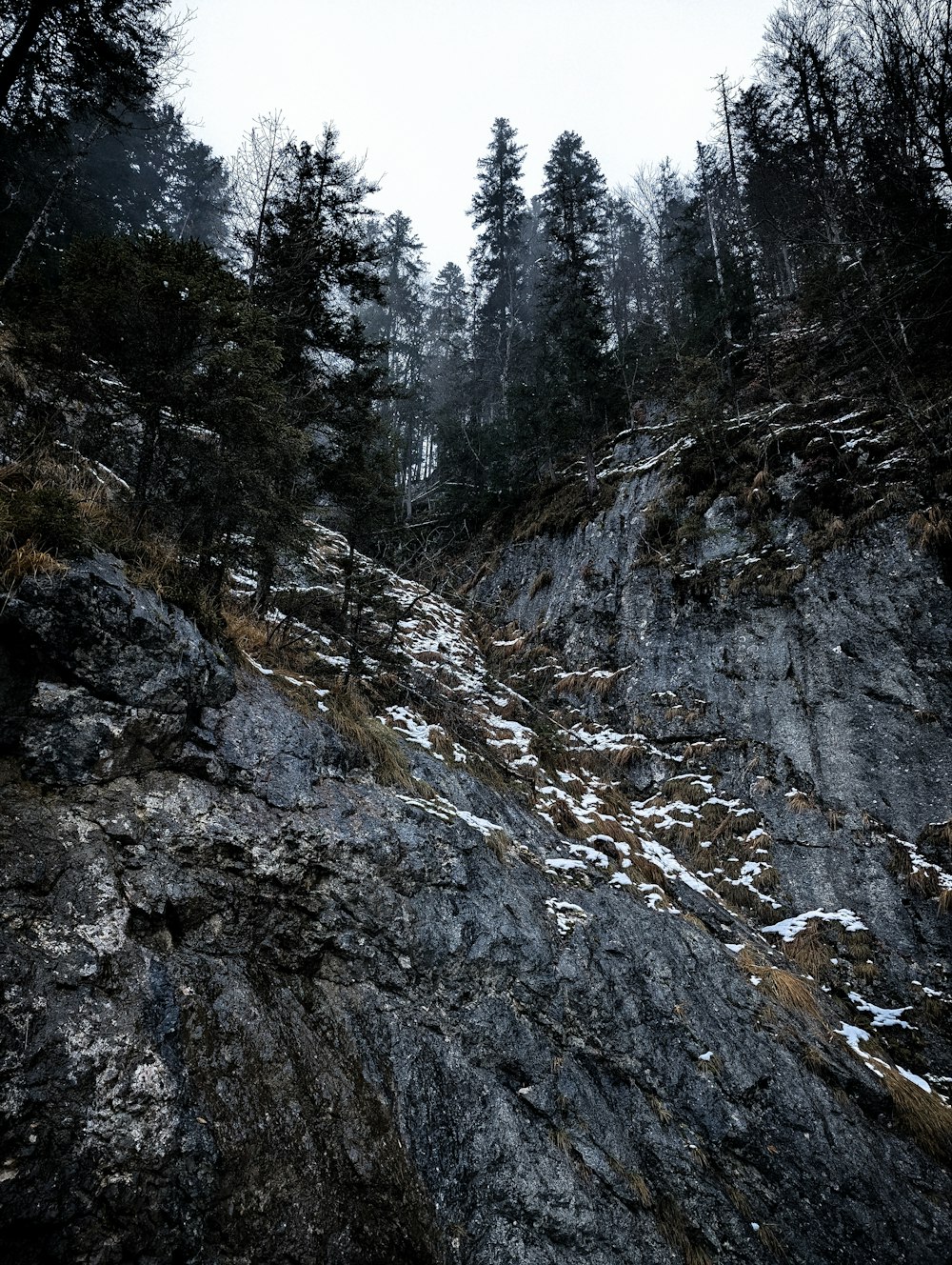 a mountain side with snow on the ground