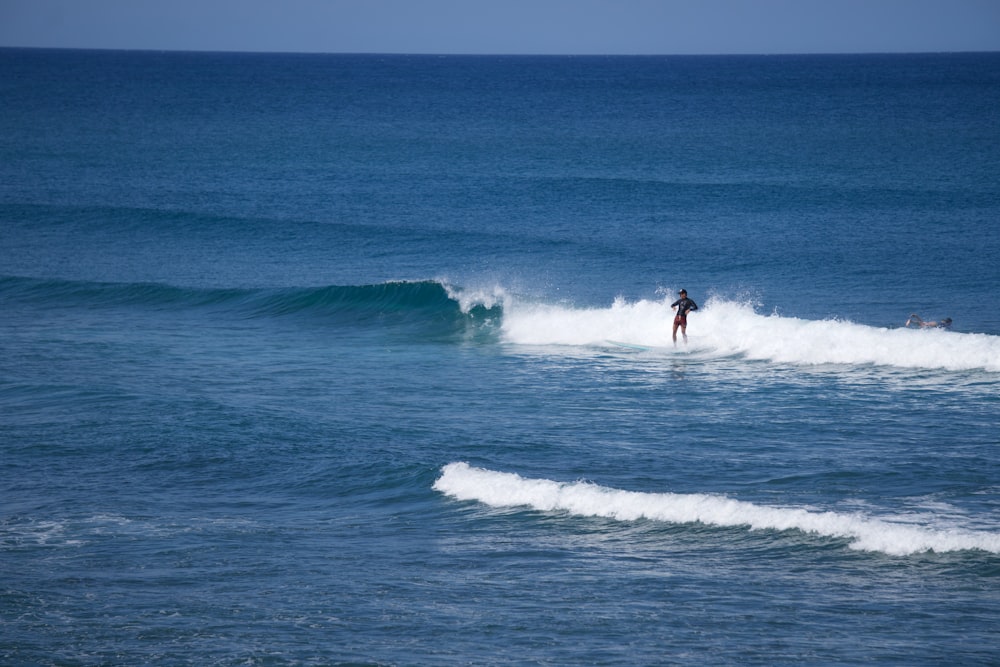 a person riding a wave on top of a surfboard