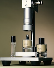 three bottles of perfume sitting next to a machine