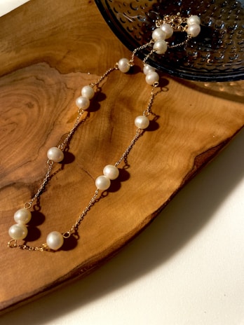 a close up of a necklace on a wooden plate