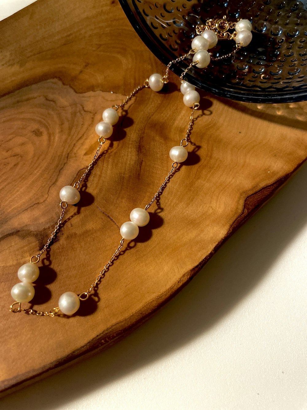 a close up of a necklace on a wooden plate