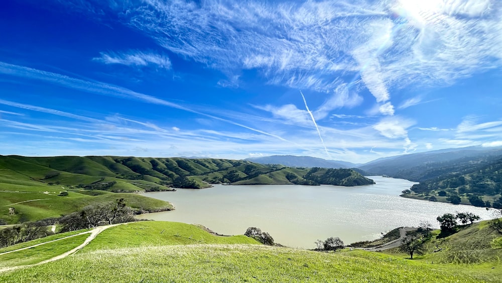 a large body of water surrounded by lush green hills