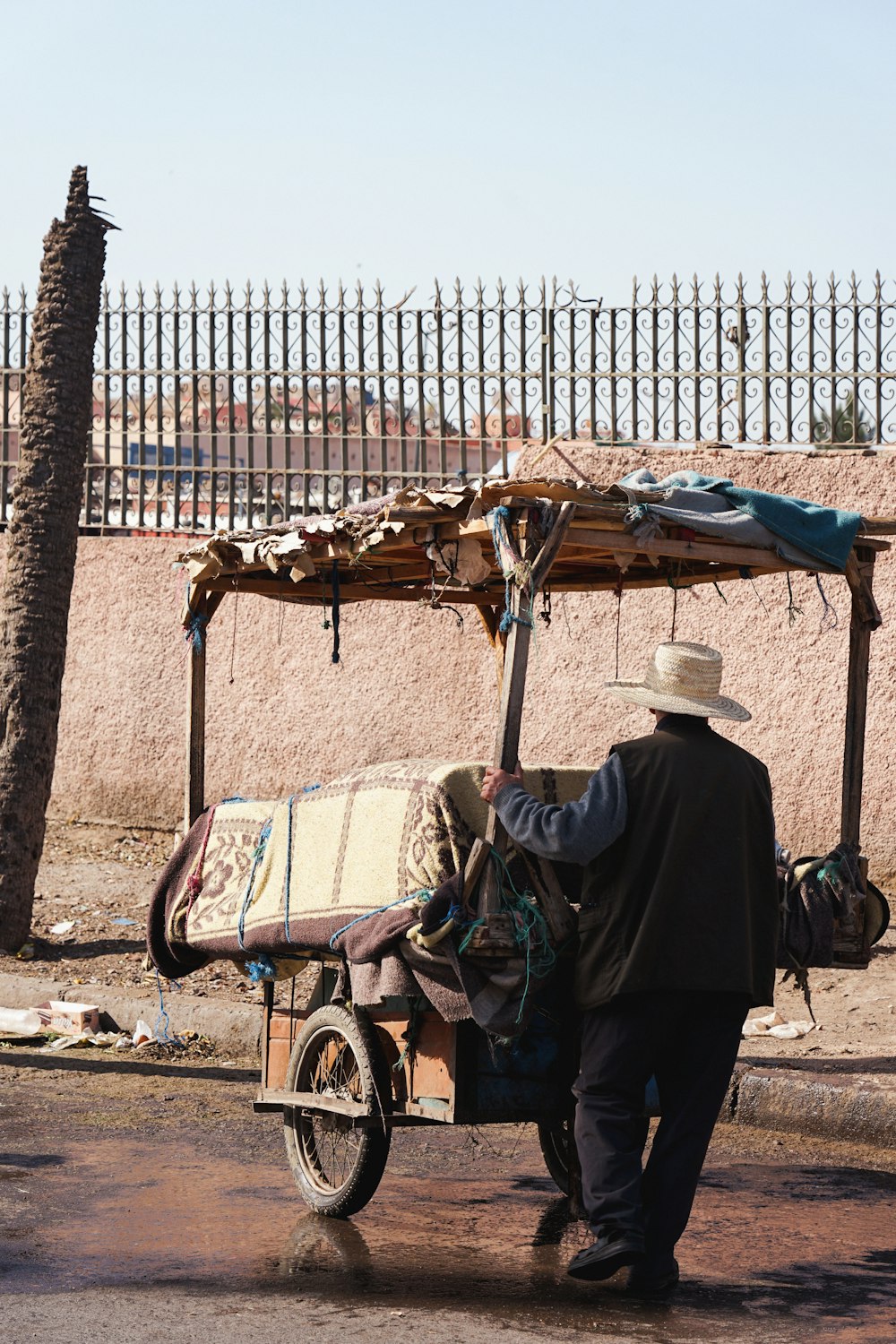 a man pushing a cart with a blanket on it