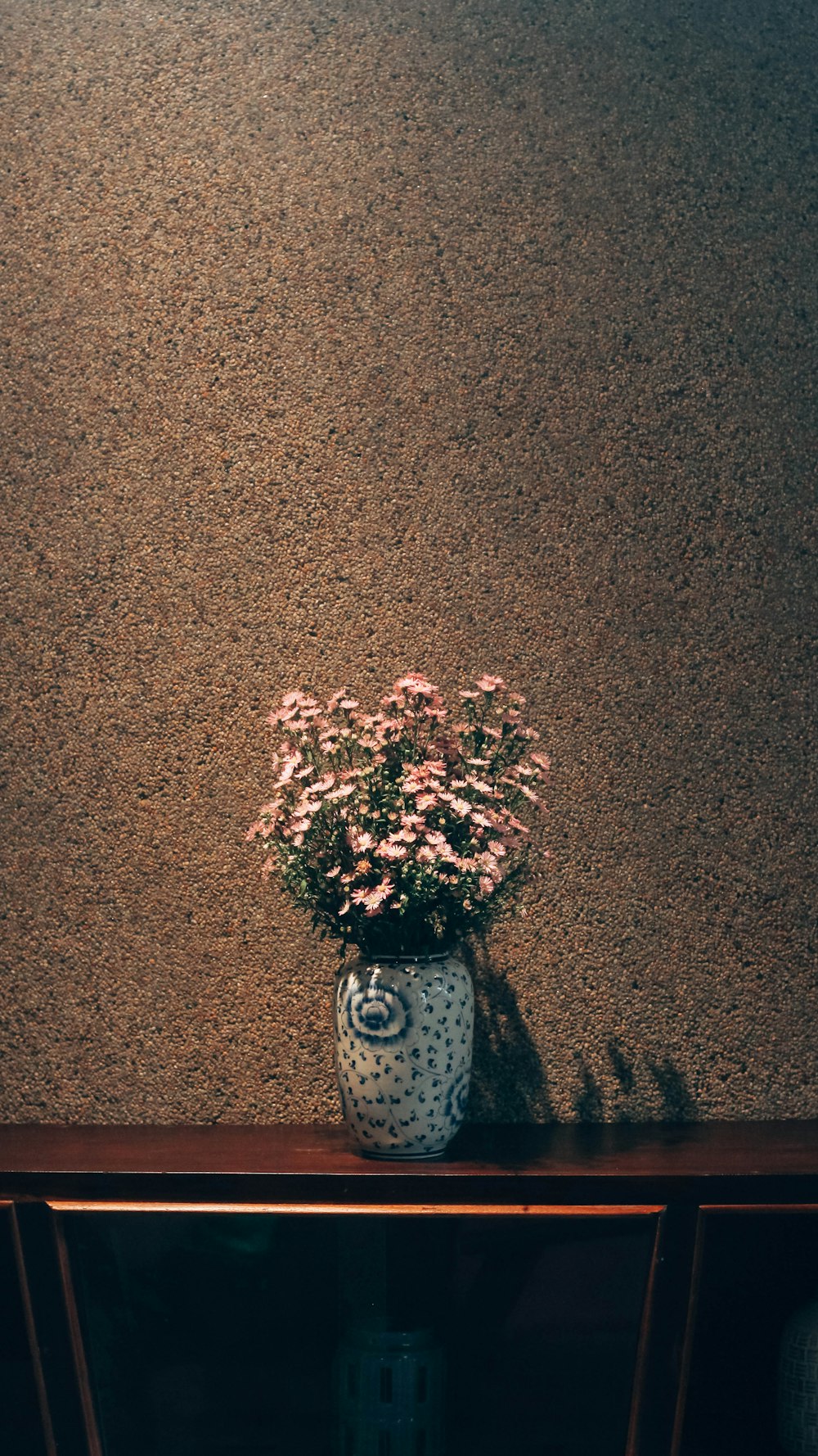 a vase of flowers sitting on a shelf