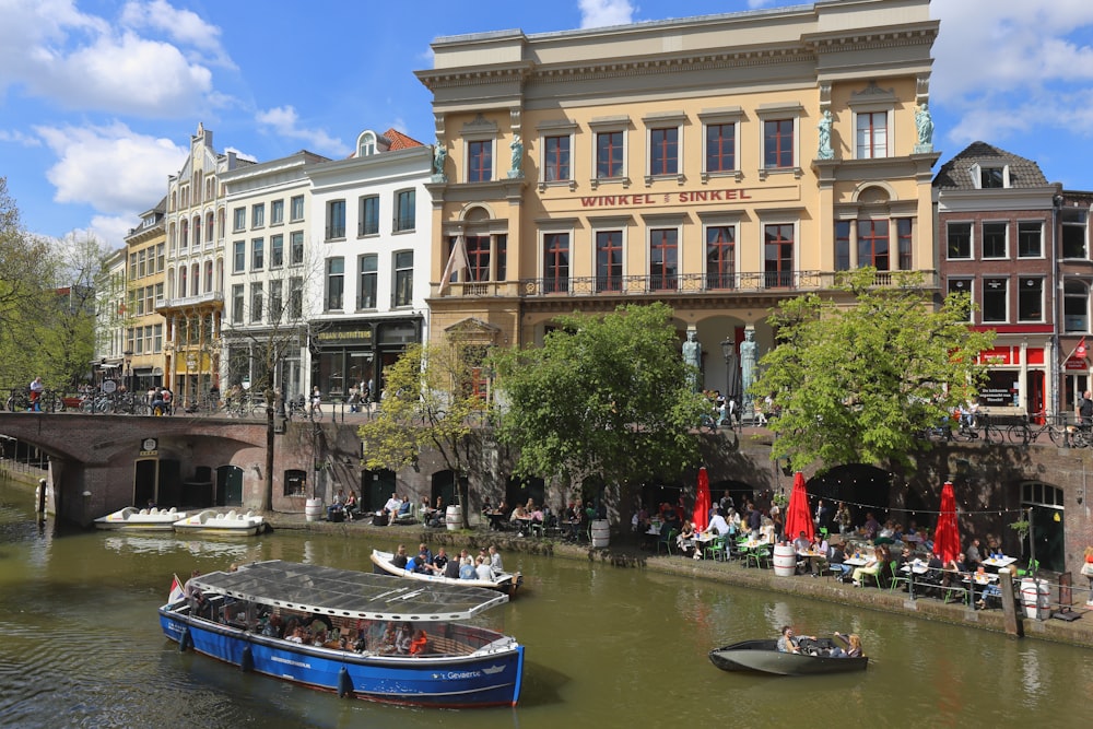 a boat floating down a river next to tall buildings