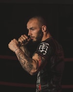 a man with a tattoo on his arm standing in a ring