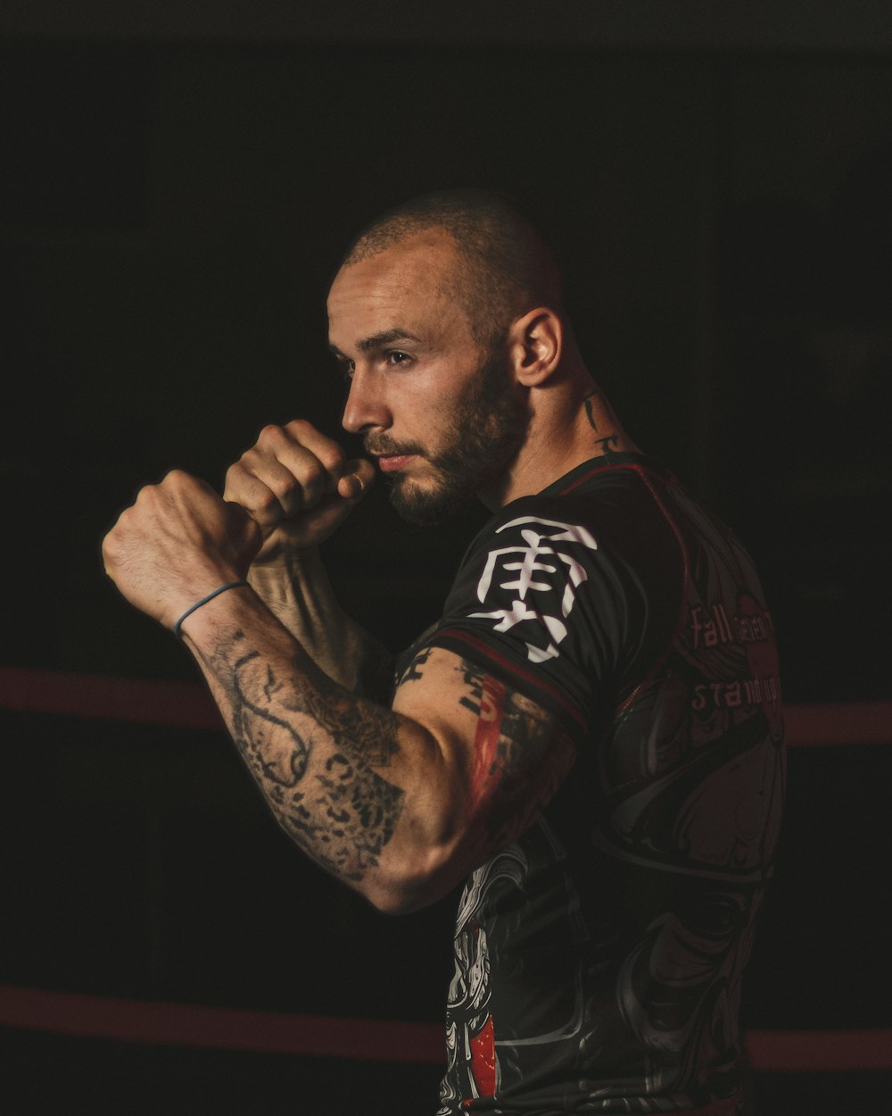 a man with a tattoo on his arm standing in a ring