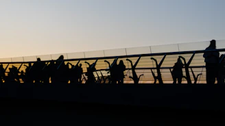 a group of people walking across a bridge