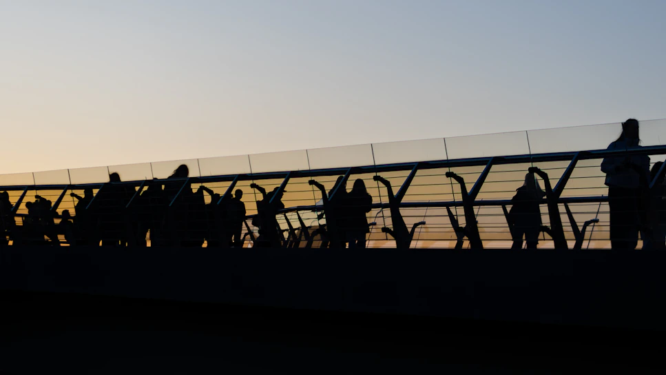 a group of people walking across a bridge