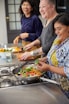 a group of women preparing food in a kitchen